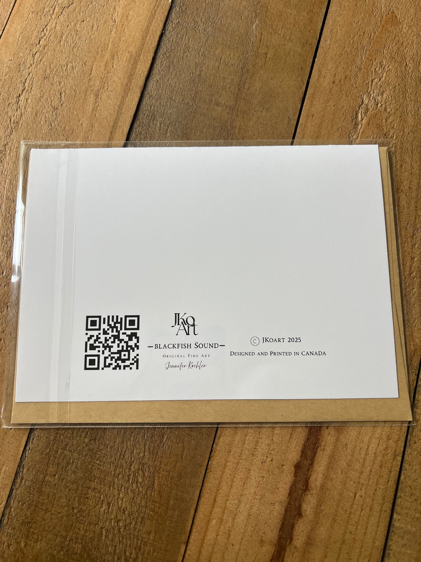 White card with a QR code and text on a wooden surface blackfish sound